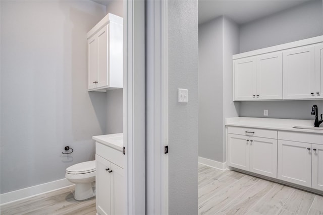 bathroom featuring wood-type flooring, vanity, and toilet