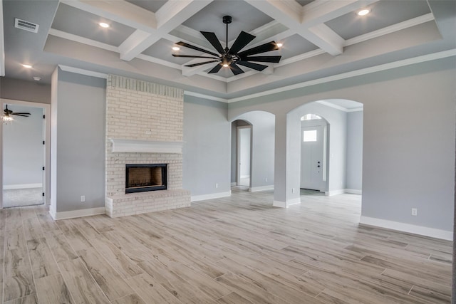 unfurnished living room with a brick fireplace, light hardwood / wood-style floors, ceiling fan, and coffered ceiling