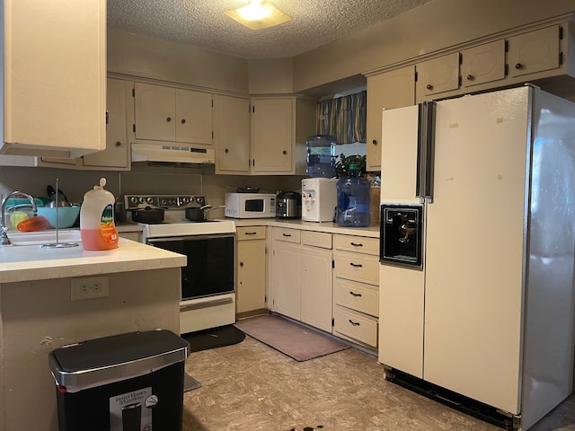 kitchen with a textured ceiling, white appliances, and sink