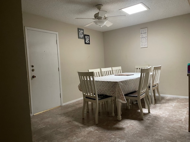 dining space featuring ceiling fan and a textured ceiling