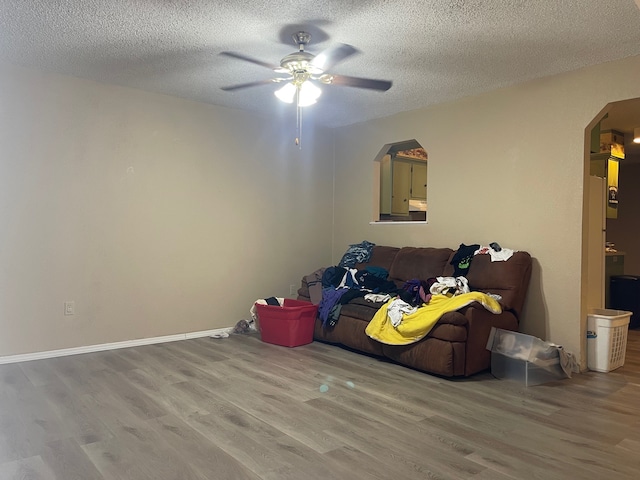 miscellaneous room featuring ceiling fan, hardwood / wood-style floors, and a textured ceiling