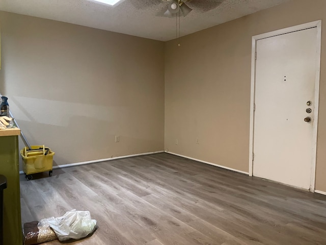 interior space with ceiling fan, a textured ceiling, and hardwood / wood-style floors