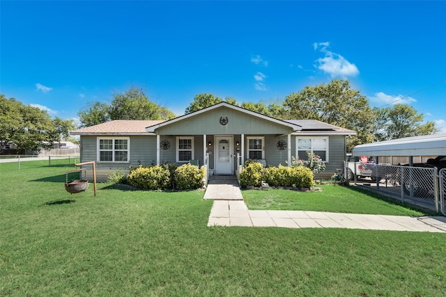 view of front facade featuring a front yard, covered porch, and a carport