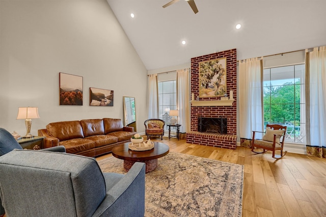 living room with ceiling fan, a healthy amount of sunlight, light hardwood / wood-style floors, and a fireplace