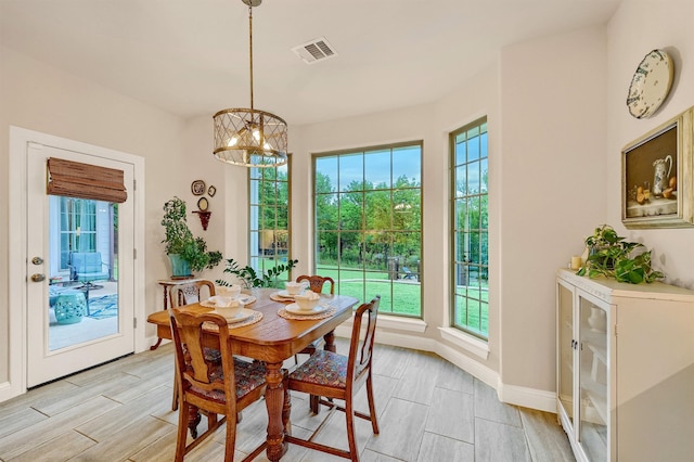 dining space featuring light wood-type flooring and a chandelier