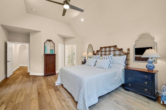 bedroom featuring ensuite bath, ceiling fan, light hardwood / wood-style floors, and lofted ceiling