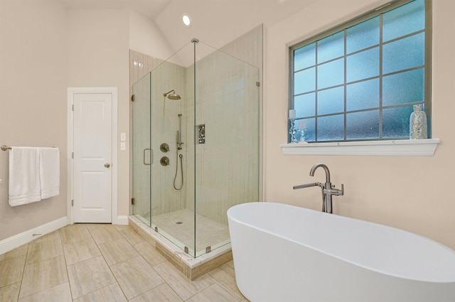 bathroom with tile patterned flooring, separate shower and tub, and vaulted ceiling