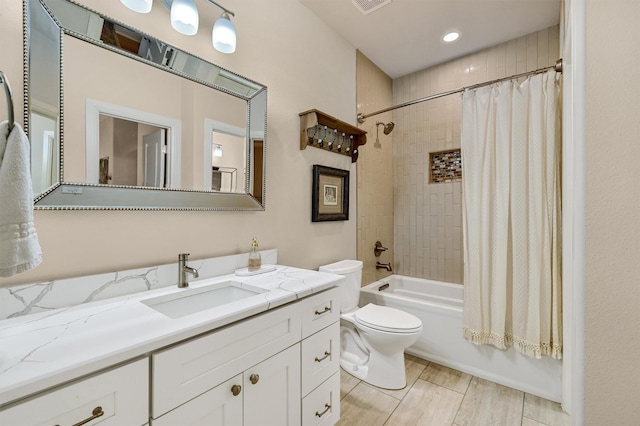 full bathroom featuring vanity, shower / bath combo, and toilet