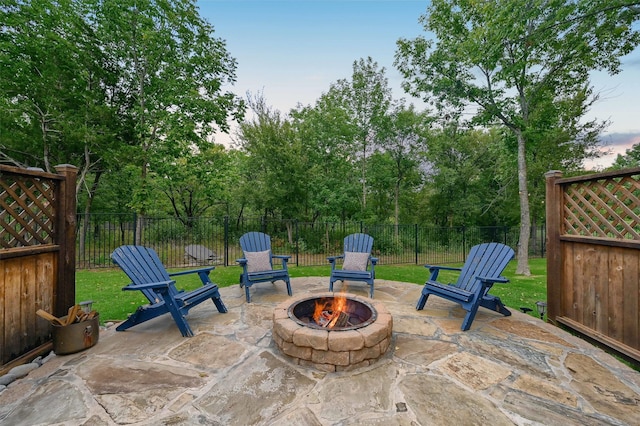 patio terrace at dusk featuring a yard and a fire pit