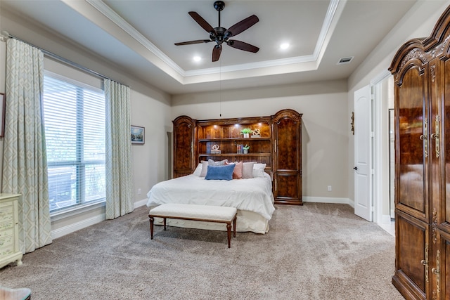 bedroom with ceiling fan, multiple windows, a raised ceiling, and light colored carpet