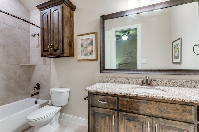 full bathroom featuring ceiling fan, vanity, tile patterned floors, toilet, and tiled shower / bath combo