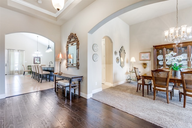 dining area with dark hardwood / wood-style floors, a chandelier, and high vaulted ceiling