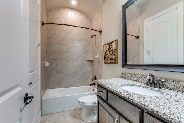 full bathroom with tile patterned flooring, tiled shower / bath, vanity, toilet, and vaulted ceiling