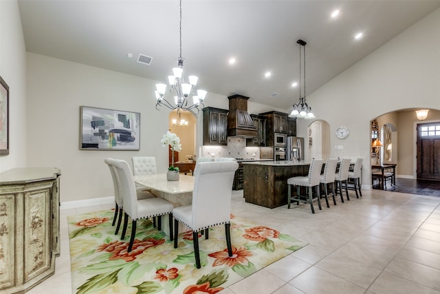 dining area featuring high vaulted ceiling, a notable chandelier, light tile patterned flooring, and sink