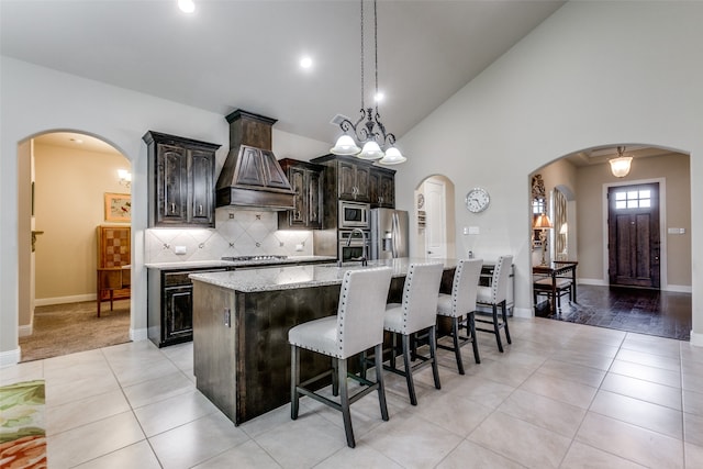 kitchen with a chandelier, appliances with stainless steel finishes, dark brown cabinets, and a spacious island