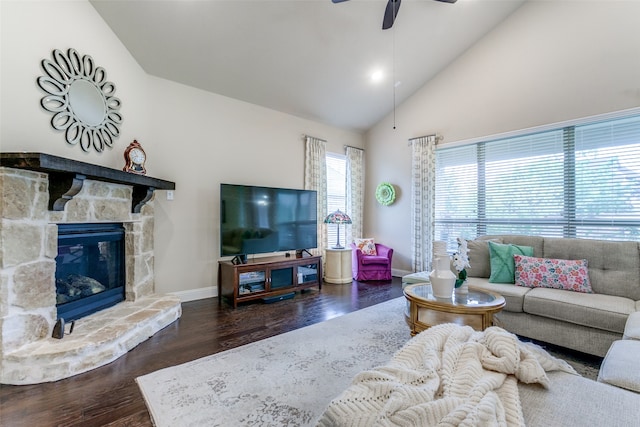 living room featuring a stone fireplace, high vaulted ceiling, dark hardwood / wood-style floors, and ceiling fan