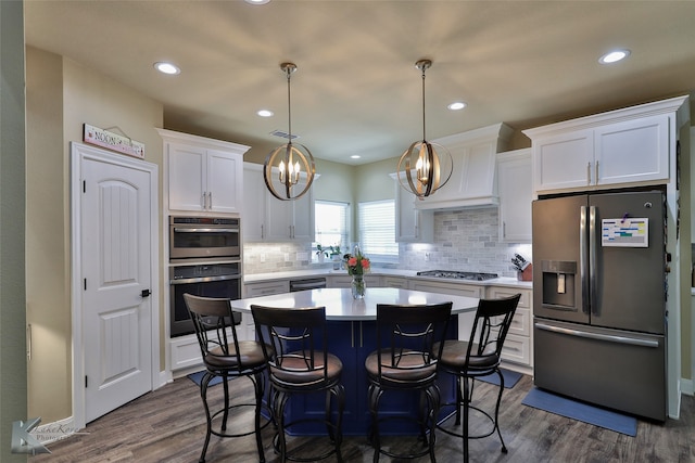 kitchen featuring pendant lighting, dark wood-type flooring, a chandelier, white cabinetry, and appliances with stainless steel finishes