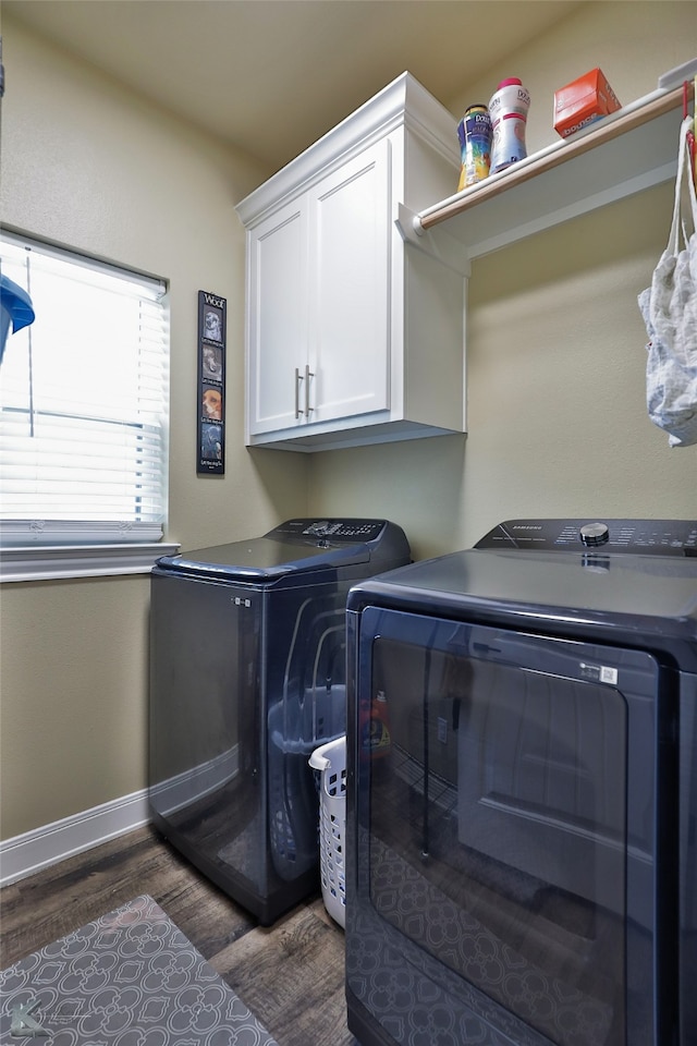 washroom with cabinets, dark hardwood / wood-style flooring, and washing machine and dryer