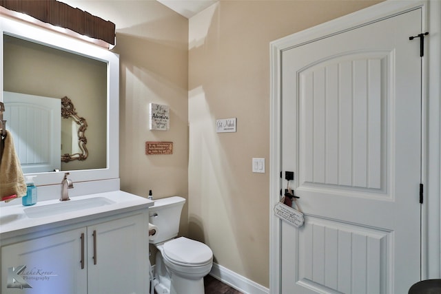 bathroom with vanity, hardwood / wood-style floors, and toilet