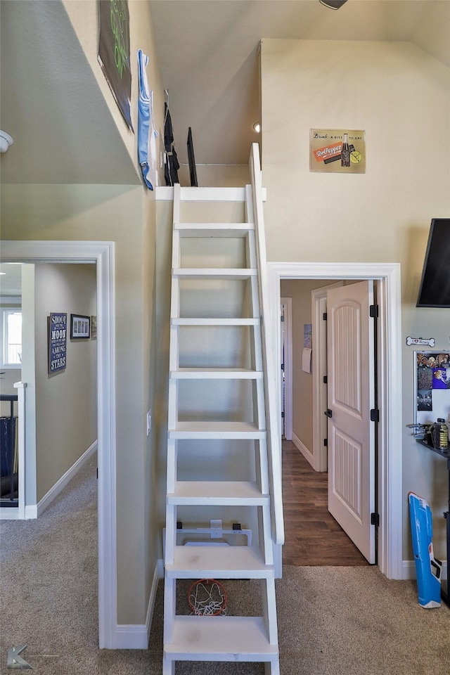 stairs with vaulted ceiling and carpet floors