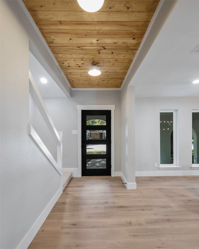 entrance foyer with ornamental molding, light wood-type flooring, plenty of natural light, and wooden ceiling