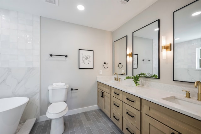 bathroom featuring a tub, vanity, and toilet