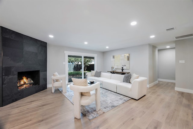 living room featuring light wood-type flooring and a premium fireplace