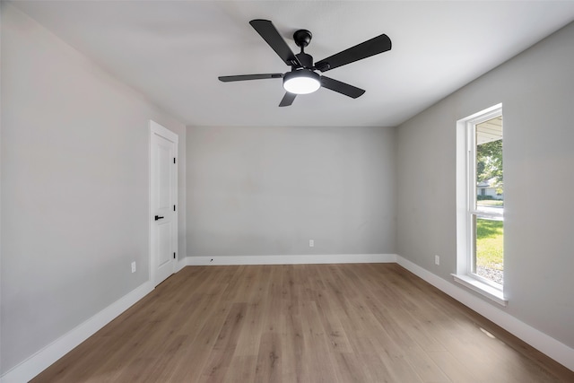 spare room featuring light wood-type flooring, ceiling fan, and a healthy amount of sunlight