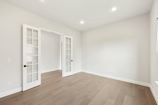 spare room with french doors and light wood-type flooring