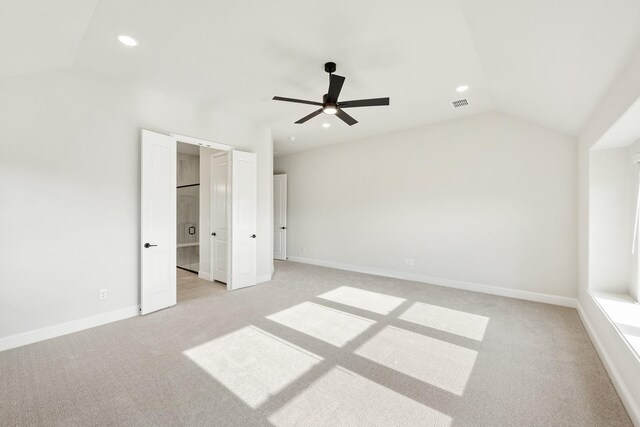 unfurnished bedroom with ceiling fan, light colored carpet, and lofted ceiling