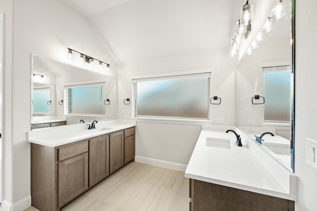 bathroom featuring vanity and lofted ceiling