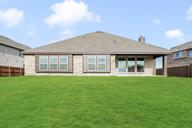 rear view of house featuring a yard