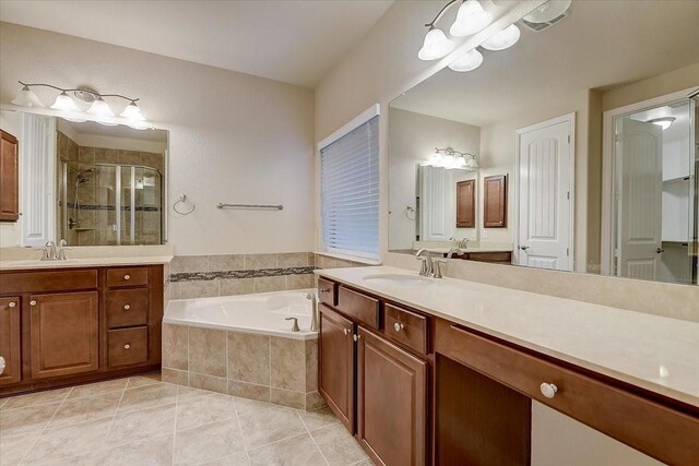 bathroom with tile patterned flooring, vanity, and separate shower and tub