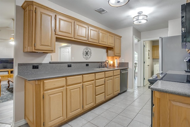 kitchen featuring washer / dryer, sink, light brown cabinets, appliances with stainless steel finishes, and light tile patterned floors