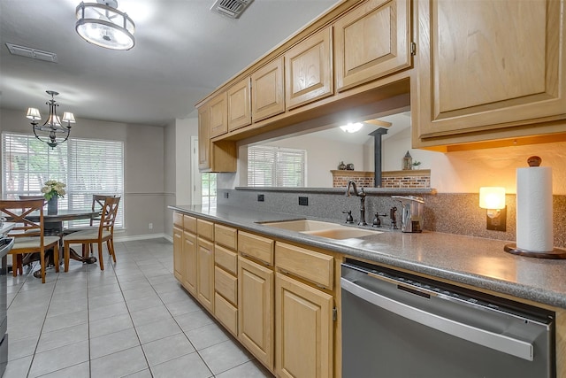 kitchen with a chandelier, sink, a wood stove, stainless steel appliances, and light tile patterned floors