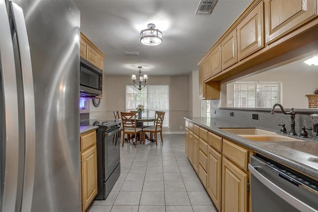 kitchen featuring sink, light tile patterned floors, stainless steel appliances, and plenty of natural light