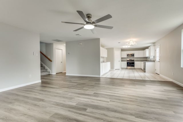 unfurnished living room with sink, ceiling fan, and light hardwood / wood-style flooring