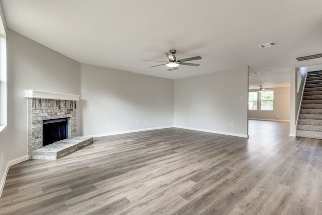 unfurnished living room with a fireplace, hardwood / wood-style floors, and ceiling fan