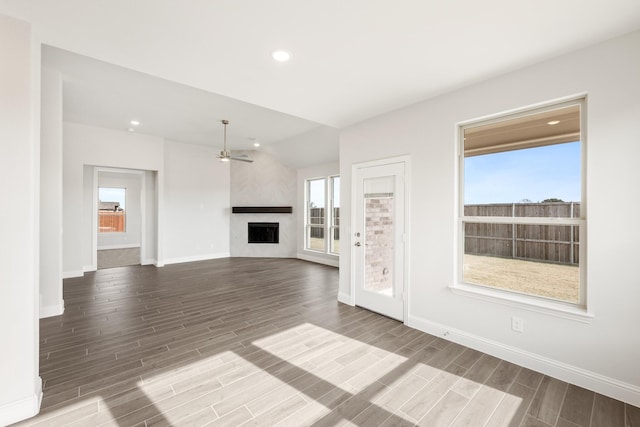 unfurnished living room with ceiling fan, a fireplace, and vaulted ceiling