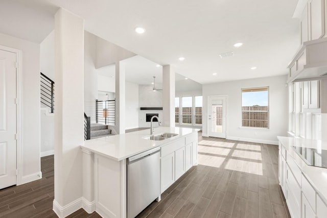 kitchen featuring dishwasher, a large fireplace, sink, white cabinets, and black electric stovetop