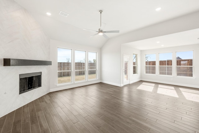 unfurnished living room featuring ceiling fan, lofted ceiling, a large fireplace, and dark hardwood / wood-style flooring