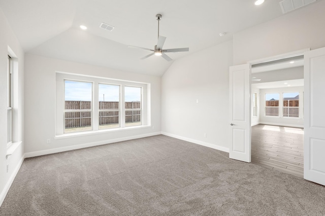 spare room featuring lofted ceiling, carpet flooring, and ceiling fan