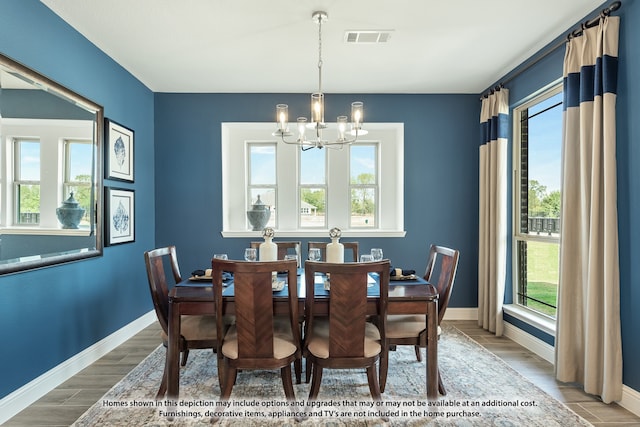 dining area with an inviting chandelier and hardwood / wood-style flooring