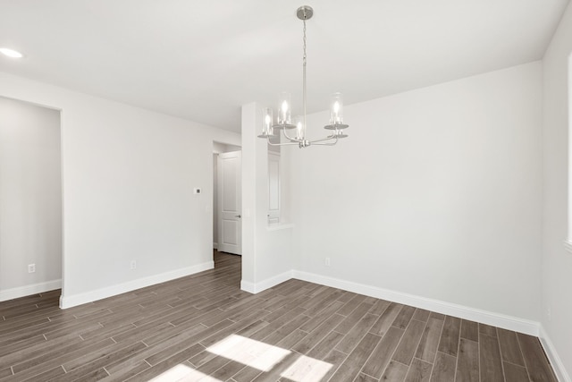 unfurnished dining area featuring dark hardwood / wood-style flooring and an inviting chandelier