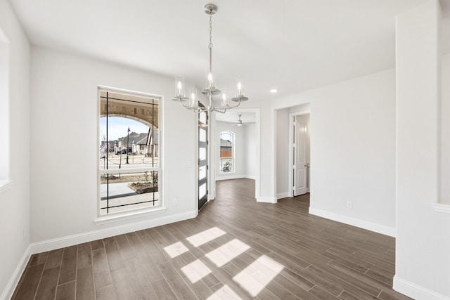 unfurnished dining area featuring dark hardwood / wood-style flooring and an inviting chandelier