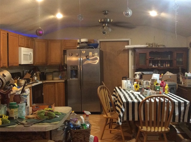 kitchen featuring ceiling fan, light hardwood / wood-style floors, vaulted ceiling, and stainless steel fridge with ice dispenser