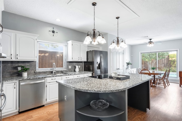 kitchen featuring light hardwood / wood-style flooring, white cabinets, stainless steel appliances, and a kitchen island