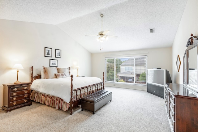 bedroom with lofted ceiling, light carpet, a textured ceiling, and ceiling fan