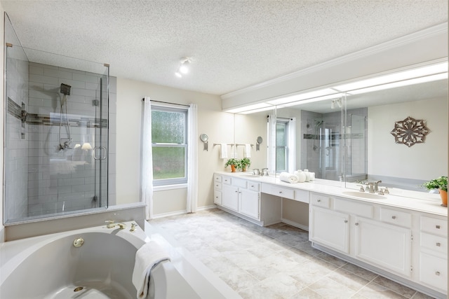 bathroom with vanity, shower with separate bathtub, and a textured ceiling