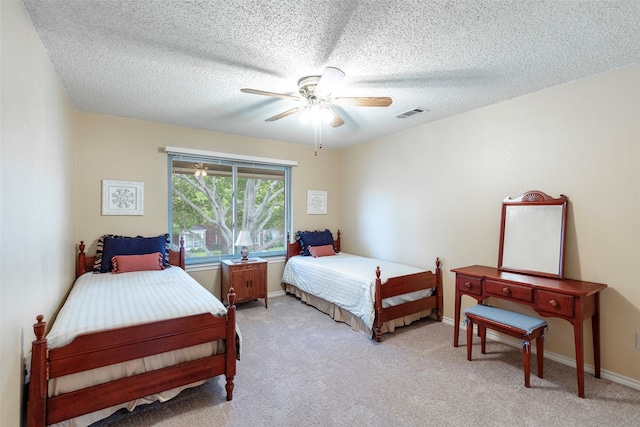 carpeted bedroom featuring a textured ceiling and ceiling fan